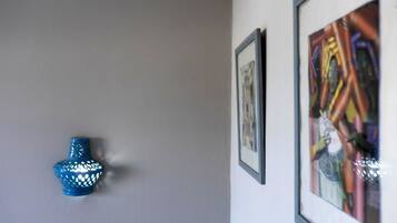 A blue decorative object on a wall, a framed artwork, and a framed picture.