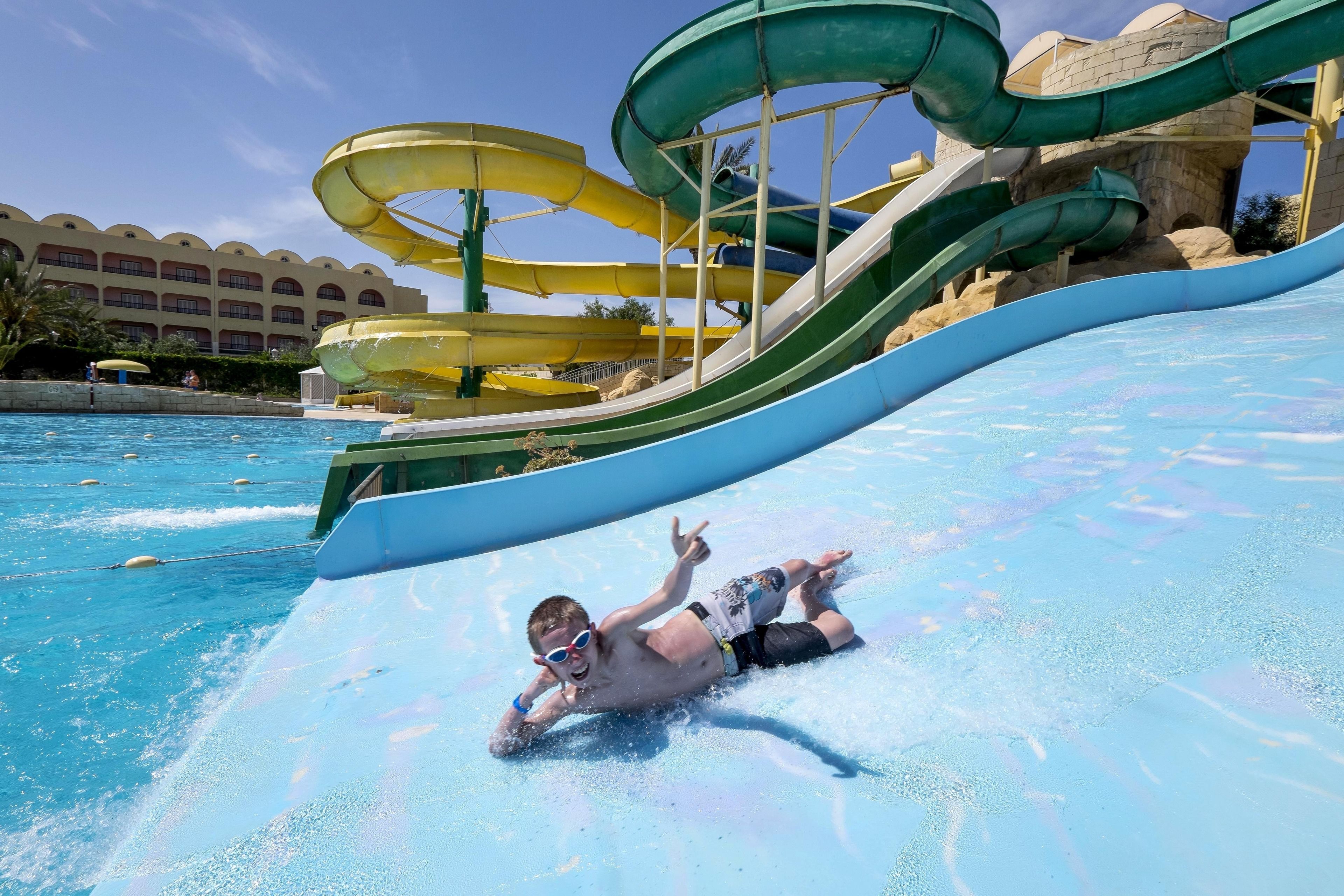 Un parque acuático con múltiples toboganes y una piscina.