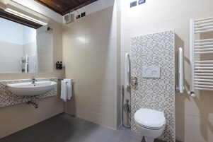 Un bagno con lavandino, WC e doccia.
