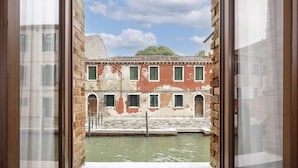 A view through a window of a building with a courtyard and a water feature. - Eurostars Cannaregio (Venice)