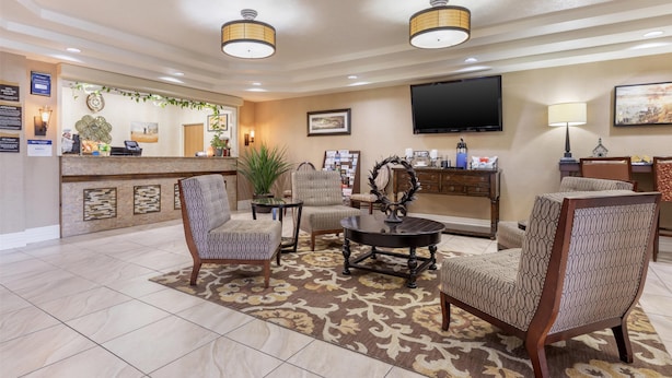 A lobby with a reception desk, seating area, and a flat-screen TV. - Best Western Parsons Inn (Parsons)