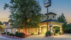 A Best Western Inn with a clear entrance, a large tree in front, and a well-lit building facade. - Best Western Parsons Inn (Parsons)