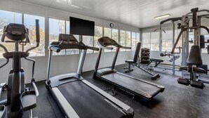 A gym with treadmills, elliptical machines, and weightlifting equipment.