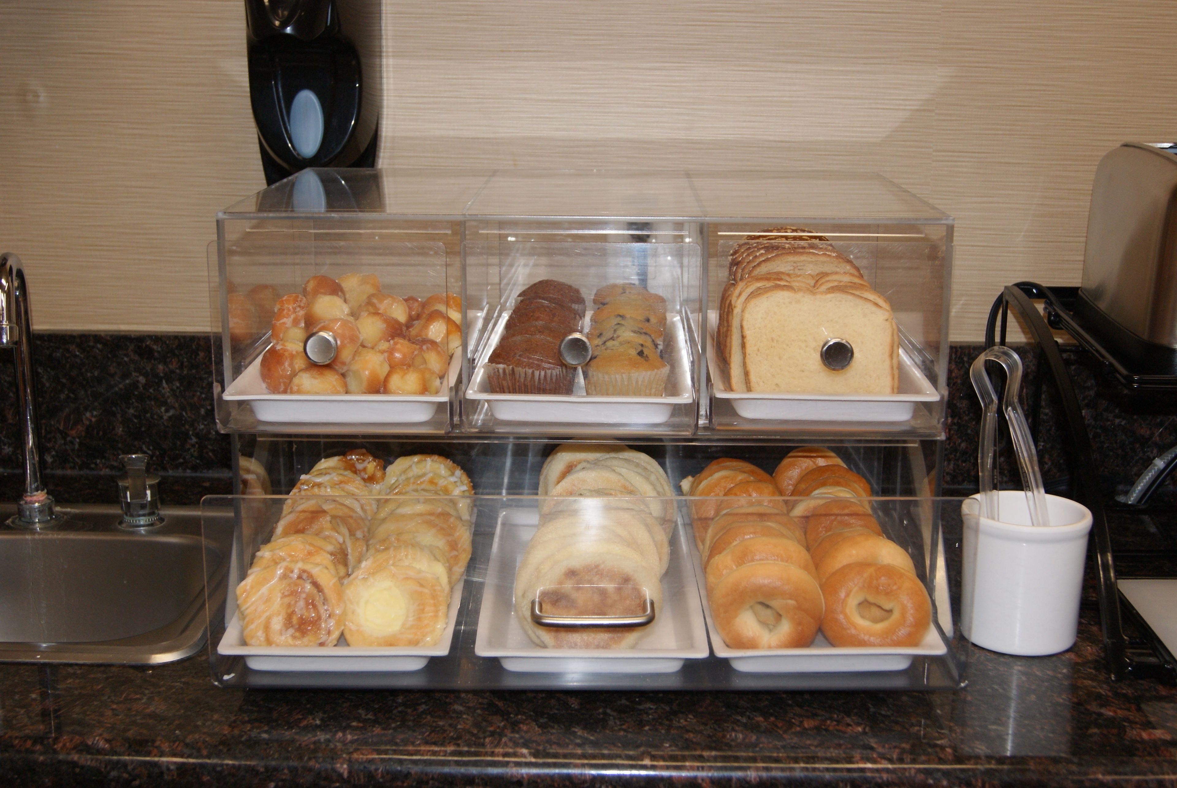 A bakery display with various baked goods in clear containers.