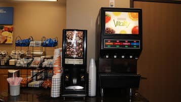 Ein Kaffee-Bereich mit Kaffeemaschine, Getränke-Automaten und einem Menübildschirm.