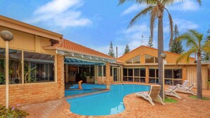 A pool area with lounge chairs and a covered patio. - Comfort Inn Bay Of Isles (Esperance)
