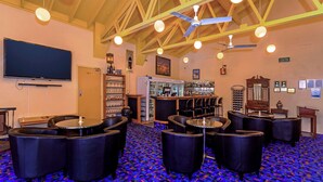 A bar area with multiple seating options, a television mounted on the wall, and a ceiling fan. - Comfort Inn Bay Of Isles (Esperance)