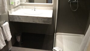 A modern bathroom with a large mirror, a sink, a shower, and a toilet. - Holiday Inn Express Madrid-San Sebastian de los Reyes by IHG (San Sebastian de los Reyes)