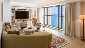 A modern living room with a large TV, comfortable seating, a dining area, and a view of the sea. - Hôtel Palais de la Méditerranée In The Unbound Collection By Hyatt (Nice)