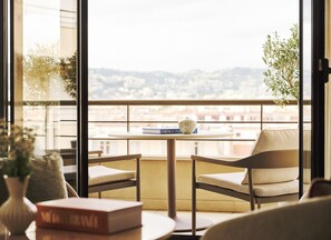 Un balcone con un tavolo, sedie, un libro e un vaso.