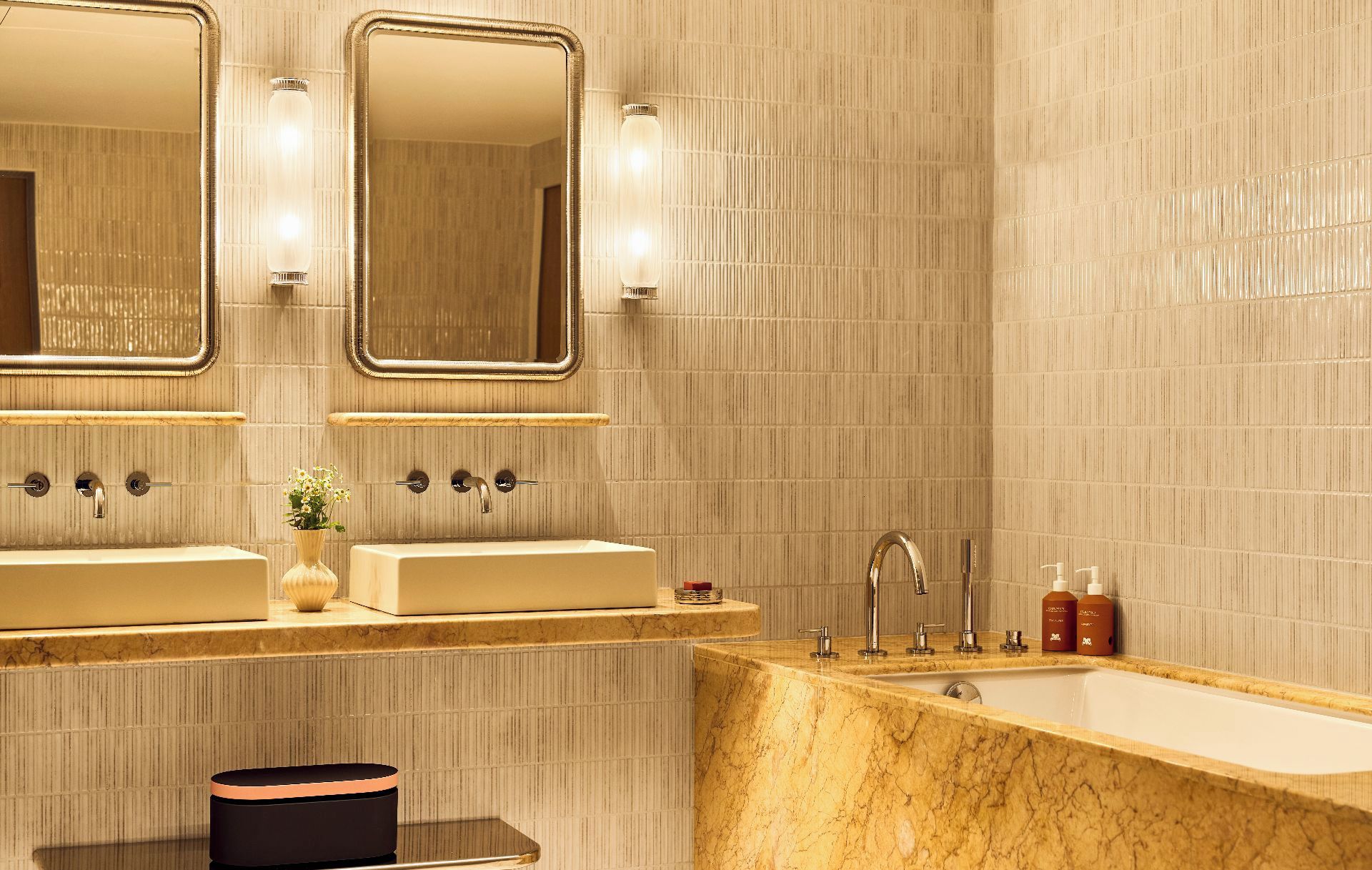 A bathroom with two sinks, a bathtub, and two mirrors.