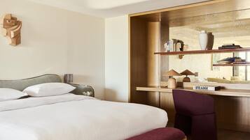 Una habitación de hotel con una cama, un escritorio, una silla y un espejo.