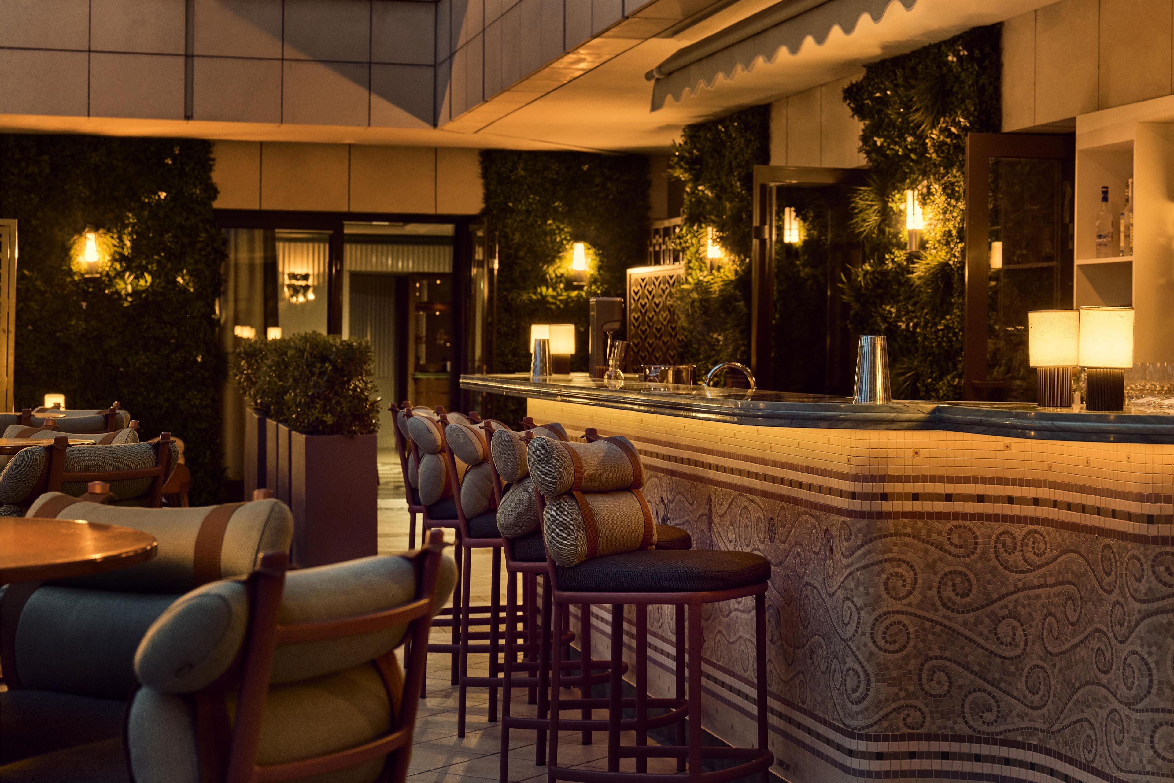 A bar area with a counter, bar stools, and ambient lighting.