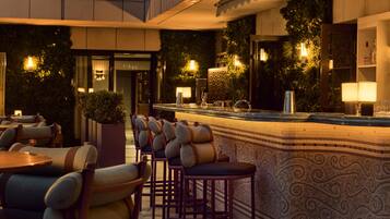 A bar area with a counter, bar stools, and ambient lighting.
