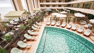 Una piscina cubierta, una piscina al aire libre, tumbonas
