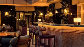 A bar area with seating, a counter, and ambient lighting.