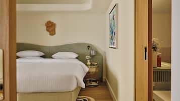 A bedroom with a bed, bedside table, and a painting on the wall.
