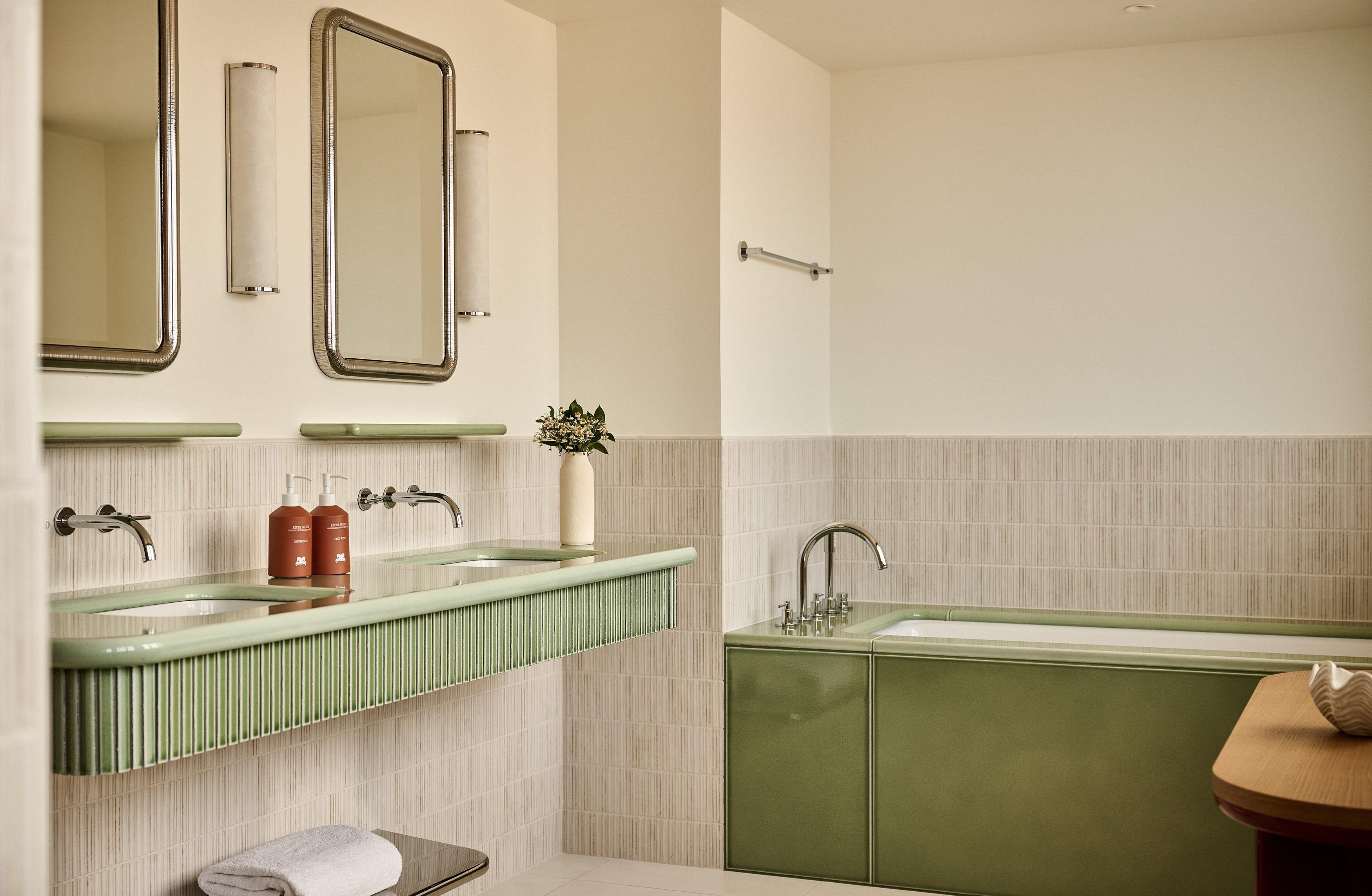 Ein Badezimmer mit zwei Waschbecken, einem Spiegel und einem Handtuchhalter.