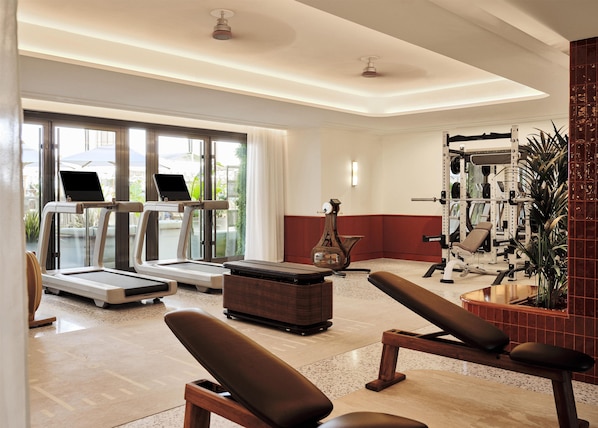 A gym with treadmills, a weight bench, and a squat rack.