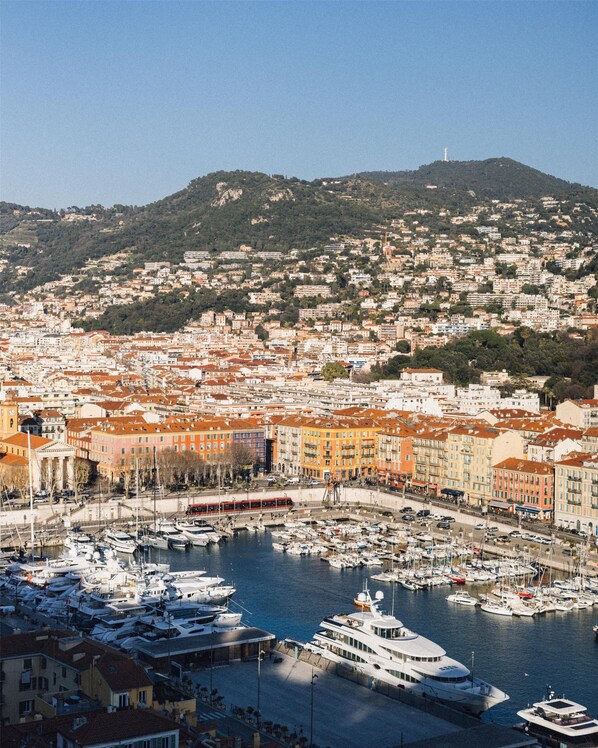 A marina with boats, a large yacht, and buildings with red roofs. - Hôtel Palais de la Méditerranée In The Unbound Collection By Hyatt (Nice)