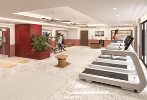 A gym with treadmills, a massage chair, and a large plant.