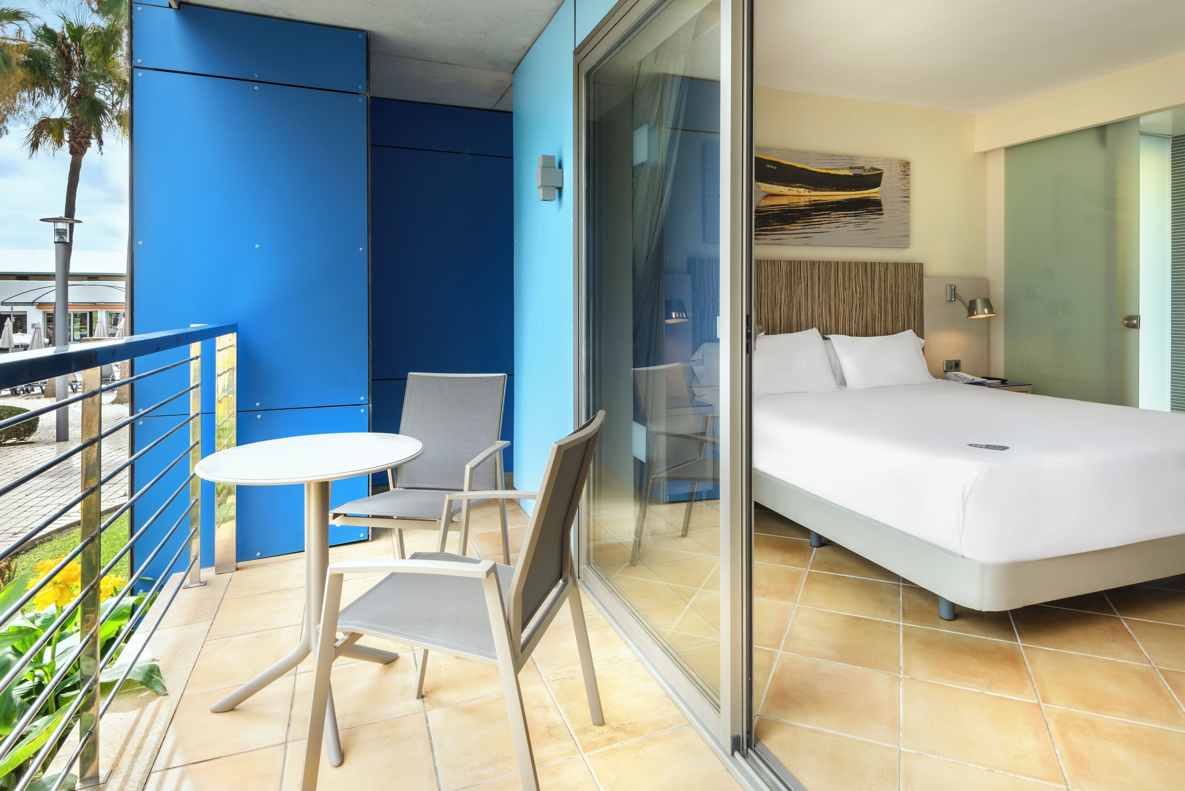 Una habitación de hotel con una cama, una mesita y dos sillas.