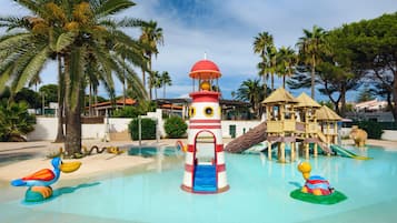 Enjoy a fun-filled day at the water park with a lighthouse play structure and a clear blue pool surrounded by palm trees.
