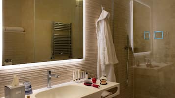 Een moderne badkamer met een grote spiegel, een wastafel, een handdoekhouder en een douche.