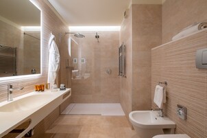 Een moderne badkamer met een grote spiegel, een bad, een douche en een wastafel.