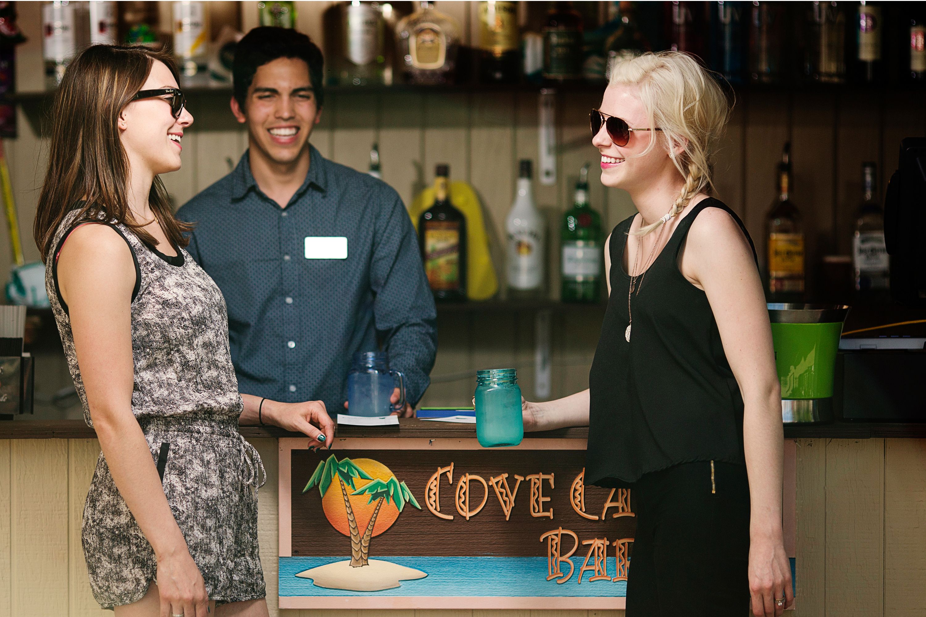 A bar counter with a sign that reads "COVE LAKI BAR".