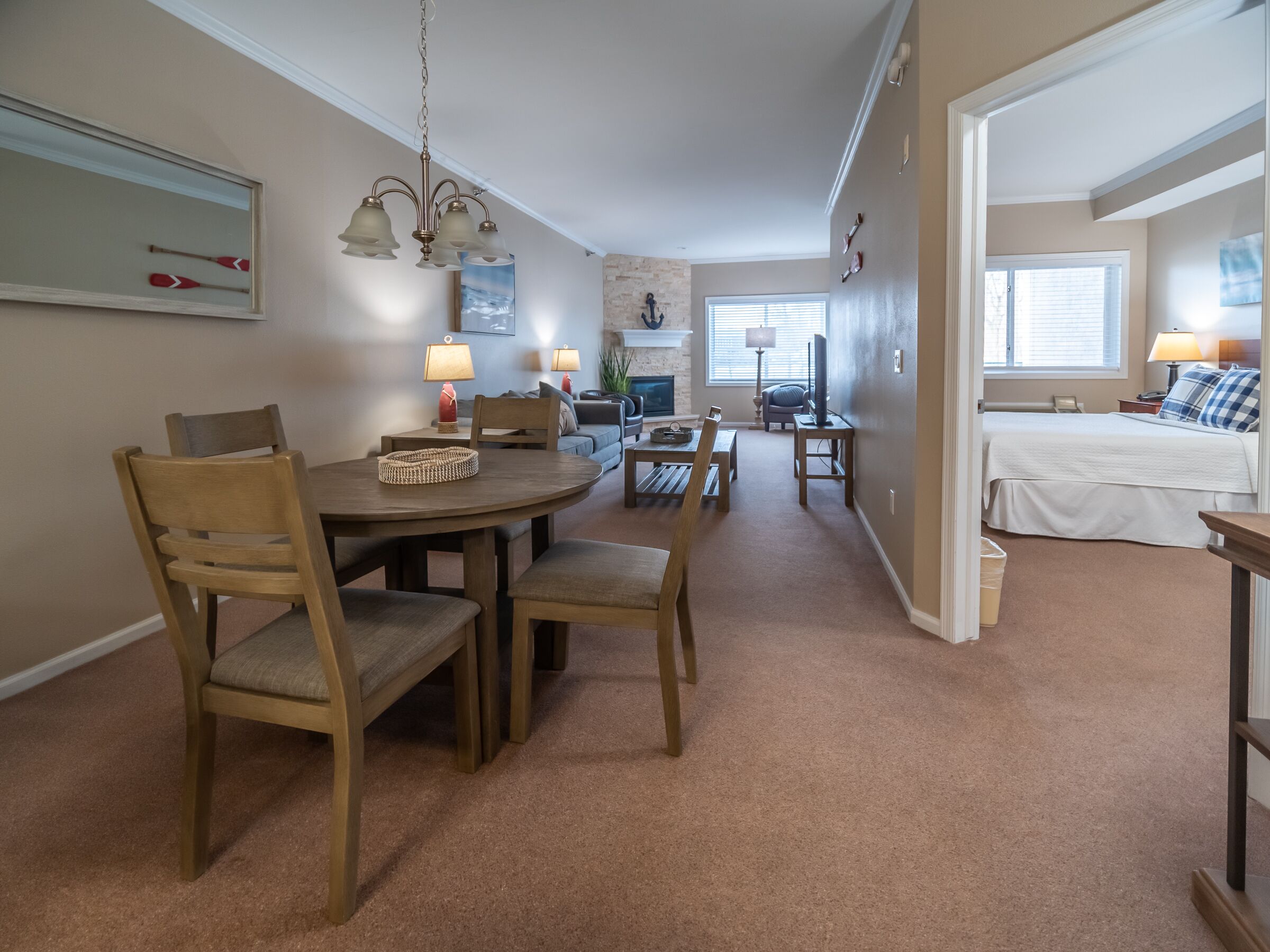 Una sala de estar acogedora con comedor, chimenea y un dormitorio con cama y ventana.