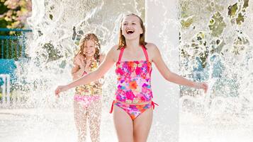 A water feature with two people in colorful swimsuits.