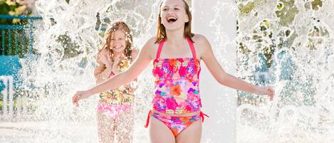 A water feature with two people in colorful swimsuits.