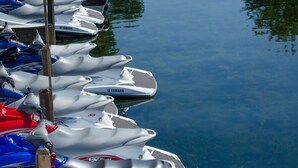 On peut voir une marina où sont amarrés plusieurs bateaux, dont des modèles Yamaha, et où flottent des drapeaux américains.