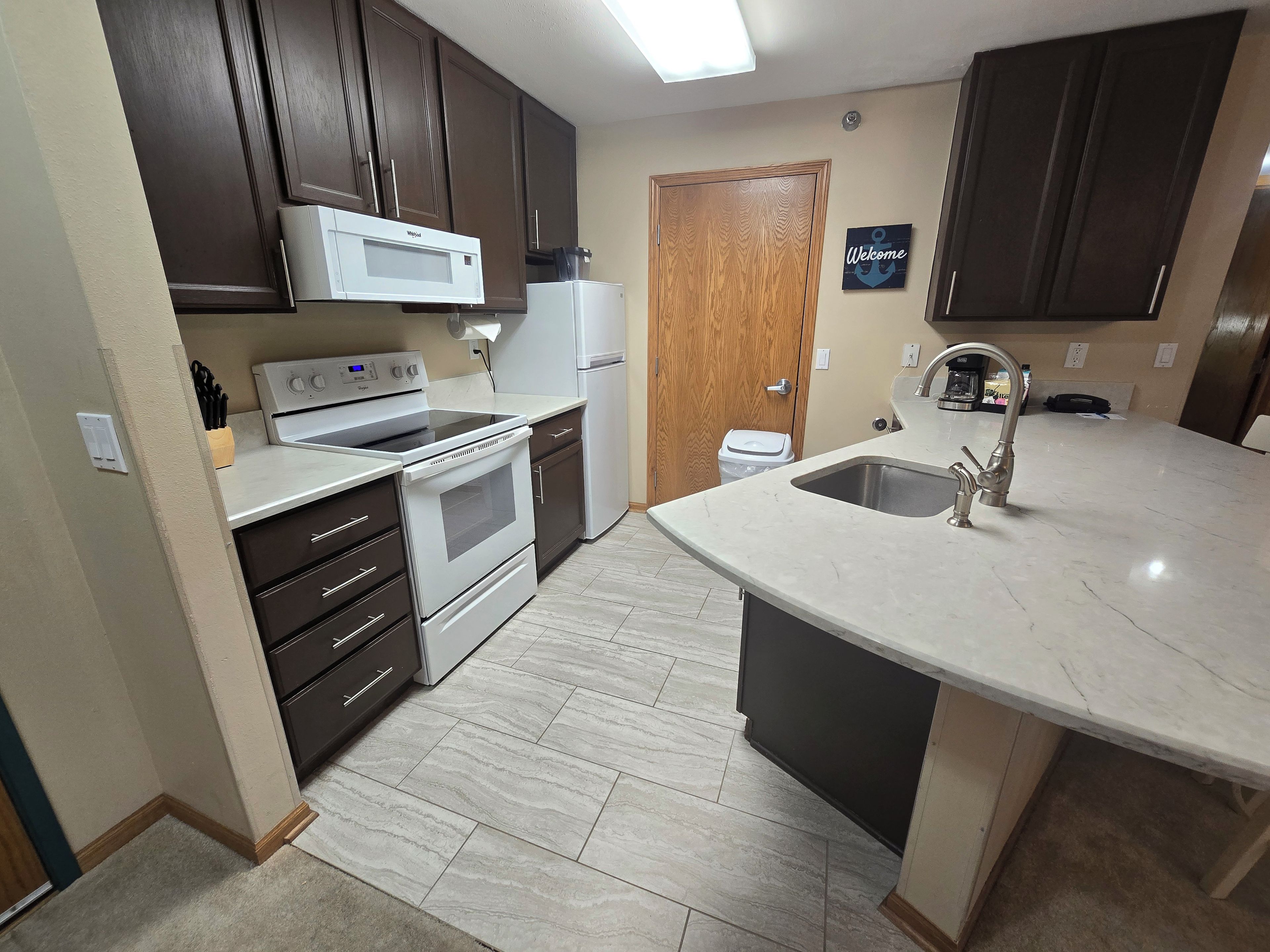 A kitchen with a built-in microwave, stove, oven, and sink.