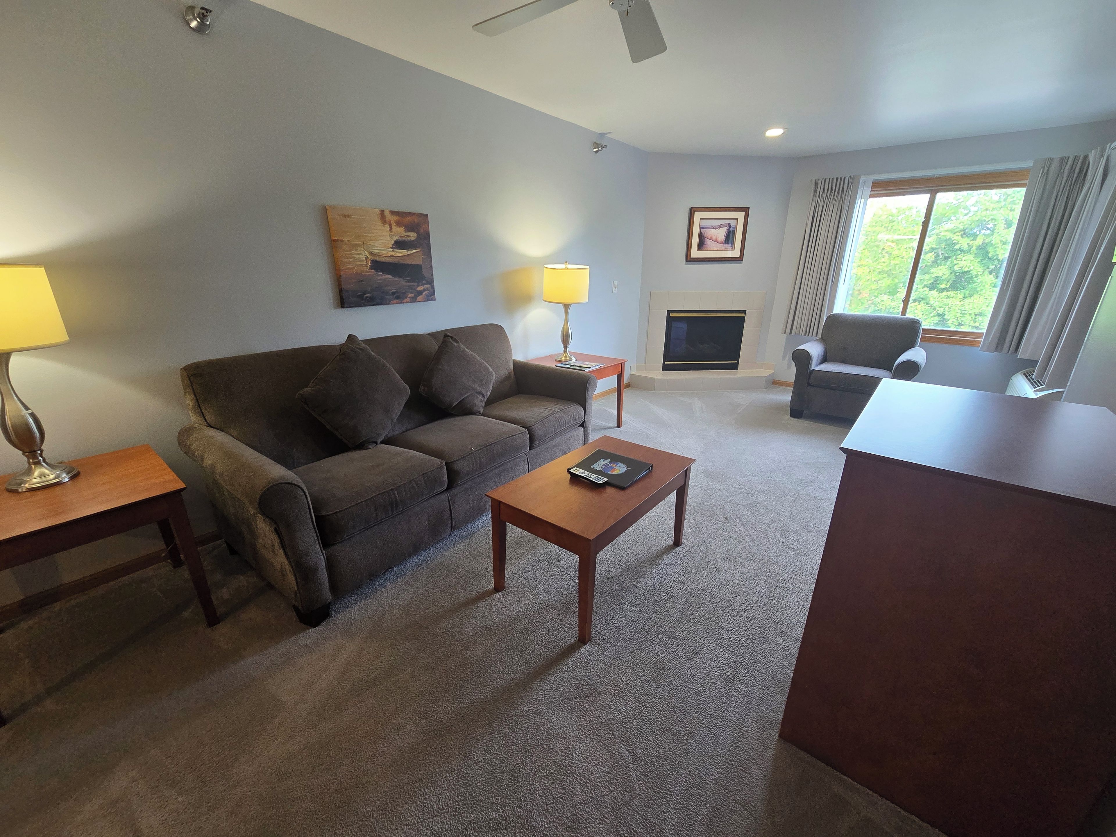 A living room with a sofa, coffee table, and a fireplace.