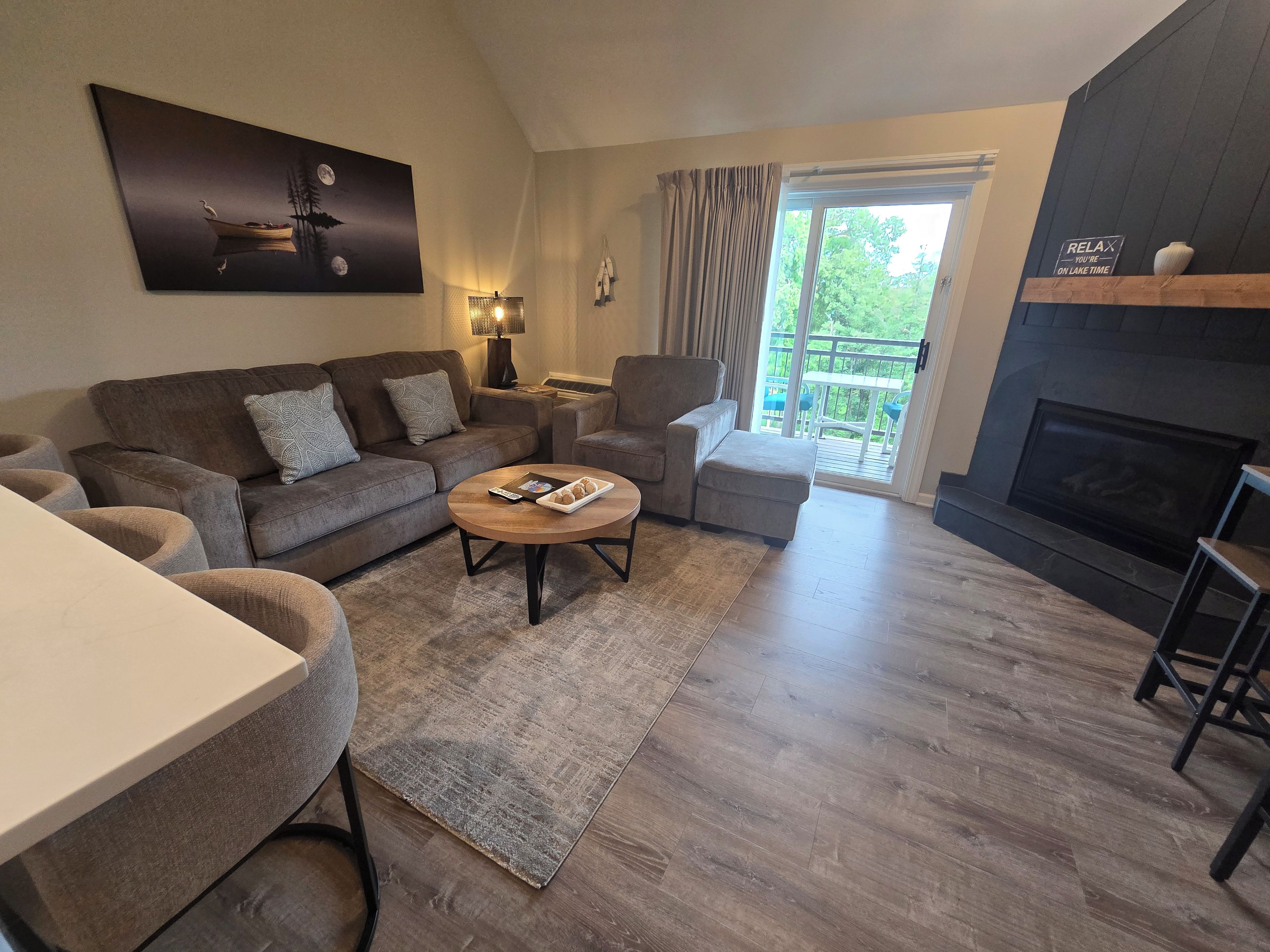 A modern living room with a sofa, armchairs, a coffee table, and a fireplace.