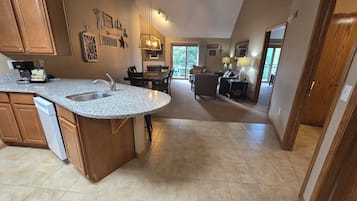 A kitchen with granite countertops, wooden cabinets, and a dishwasher.
