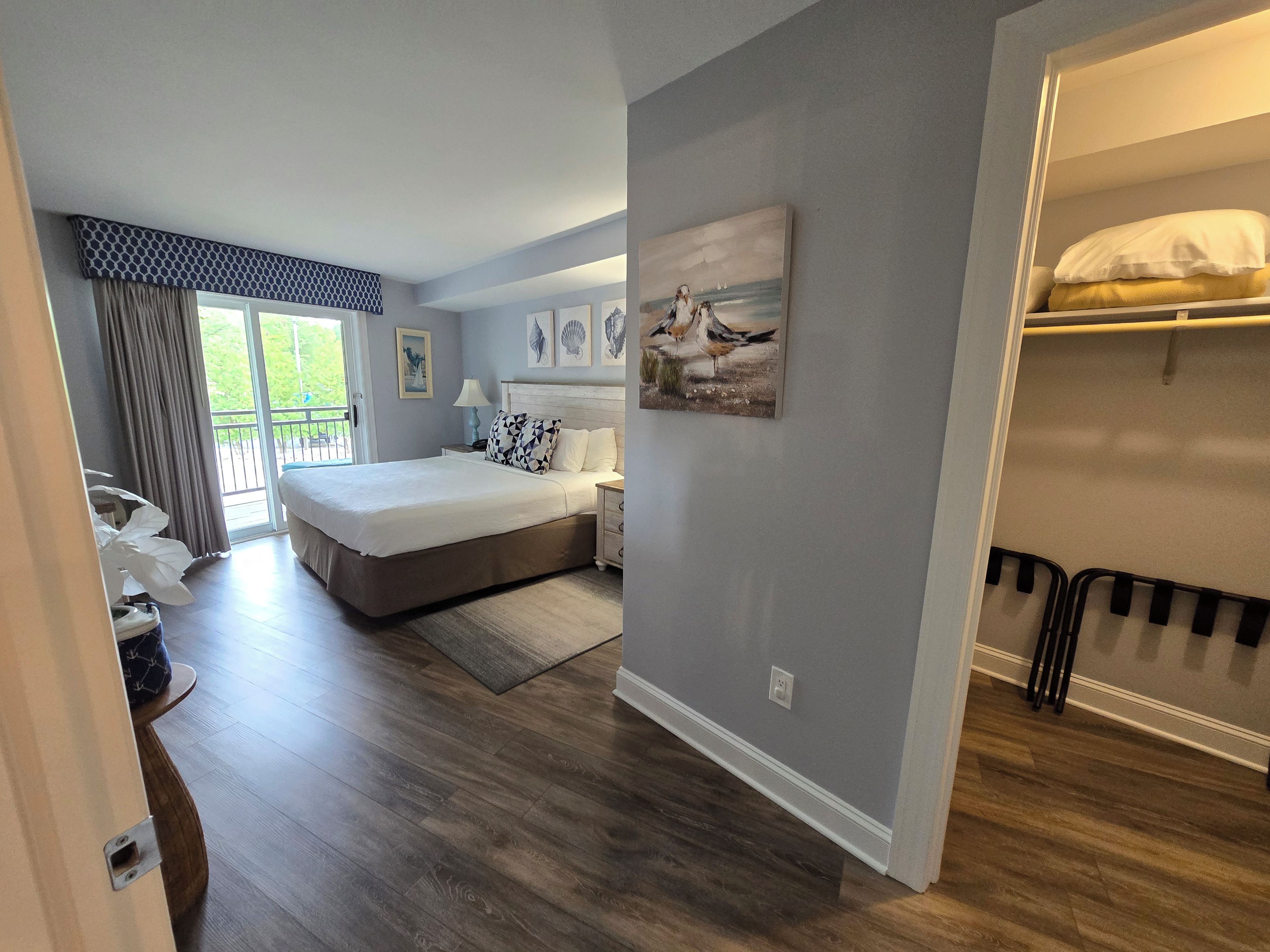 Ein Schlafzimmer mit einem Bett, einem Nachttisch, einer Lampe und einem Bild an der Wand.