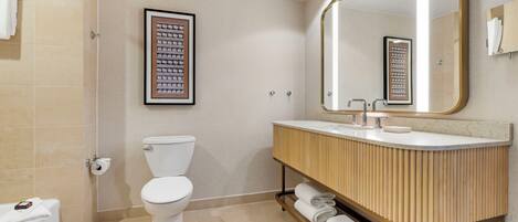 Une salle de bain moderne équipée de toilettes, d’un lavabo et d’une douche.
