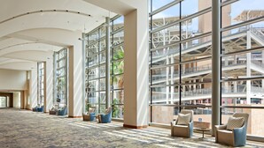 Un lobby amplio con ventanas grandes, techo curvo y zonas de estar cómodas.
