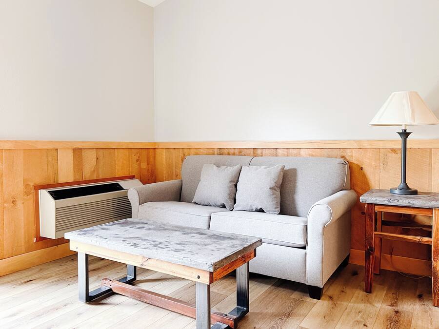 En stue med sofa, bord, lampe og radiator.
