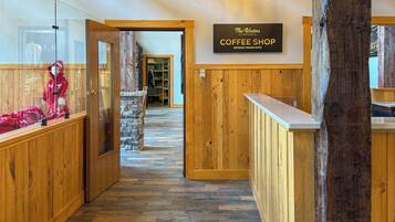 Un interior de madera con un letrero que dice 'The Waters Coffee Shop' y un suelo con motivo de espiga.