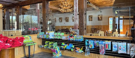 Ein rustikales Interieur mit Holzbalken, einer Chandelüster und verschiedenen Kinderspielsachen.