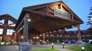 A large lodge with a prominent sign reading "The Waters." It features a spacious entrance with a covered walkway, multiple balconies, and a well-lit facade. - The Waters Of Minocqua (Minocqua)