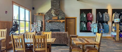 Un interior rústico con muebles de madera, una chimenea de piedra y una tienda de ropa.