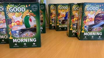 A row of 'Good Morning' juice boxes on a wooden surface.