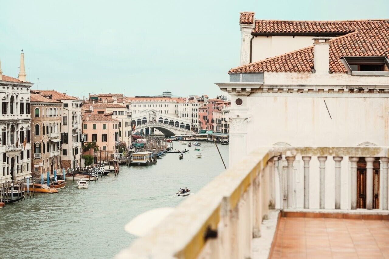 Un canal flanqueado por edificios y un puente, evocando un entorno urbano histórico.
