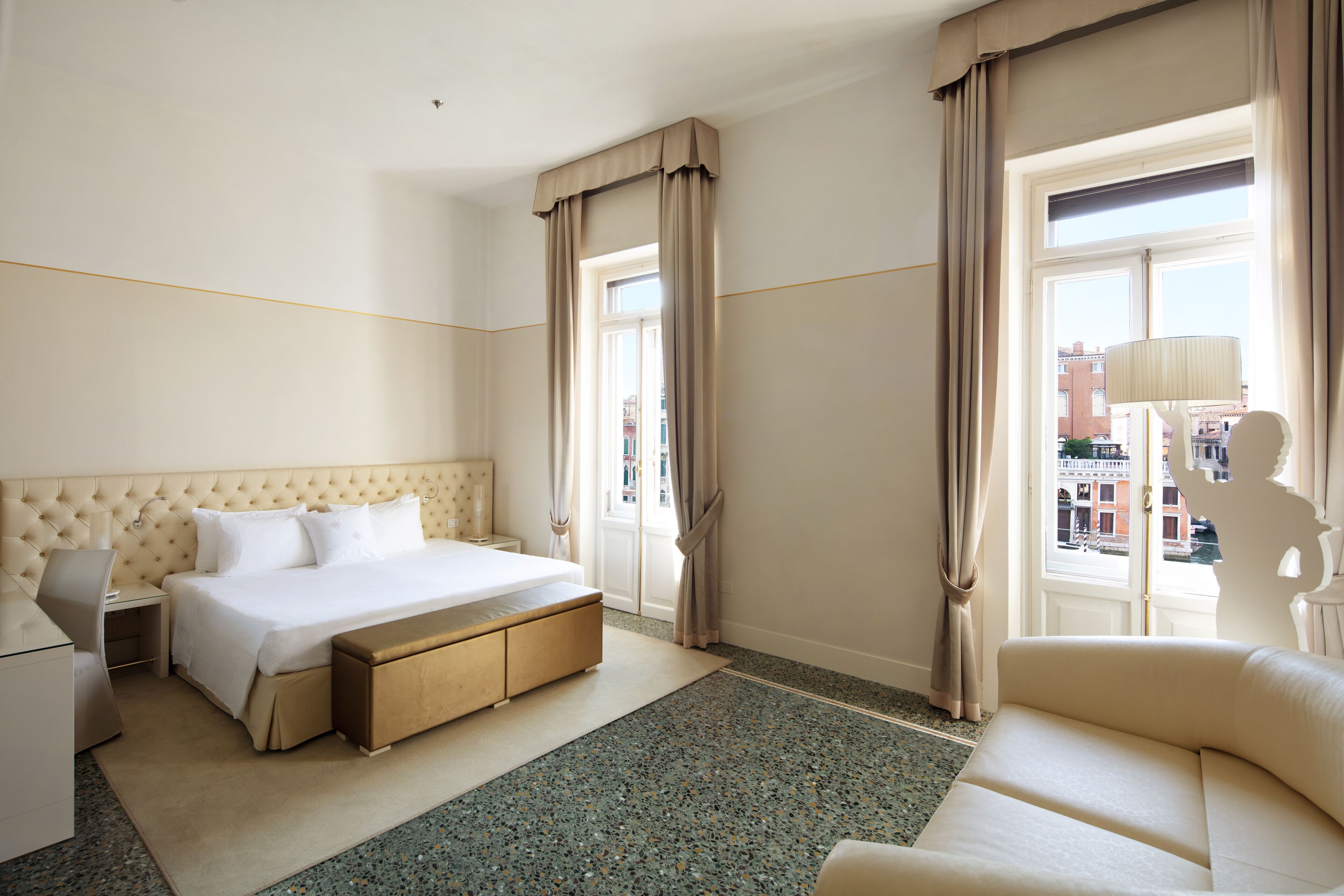 Une chambre d’hôtel avec un grand lit, un bureau, une chaise et un canapé.