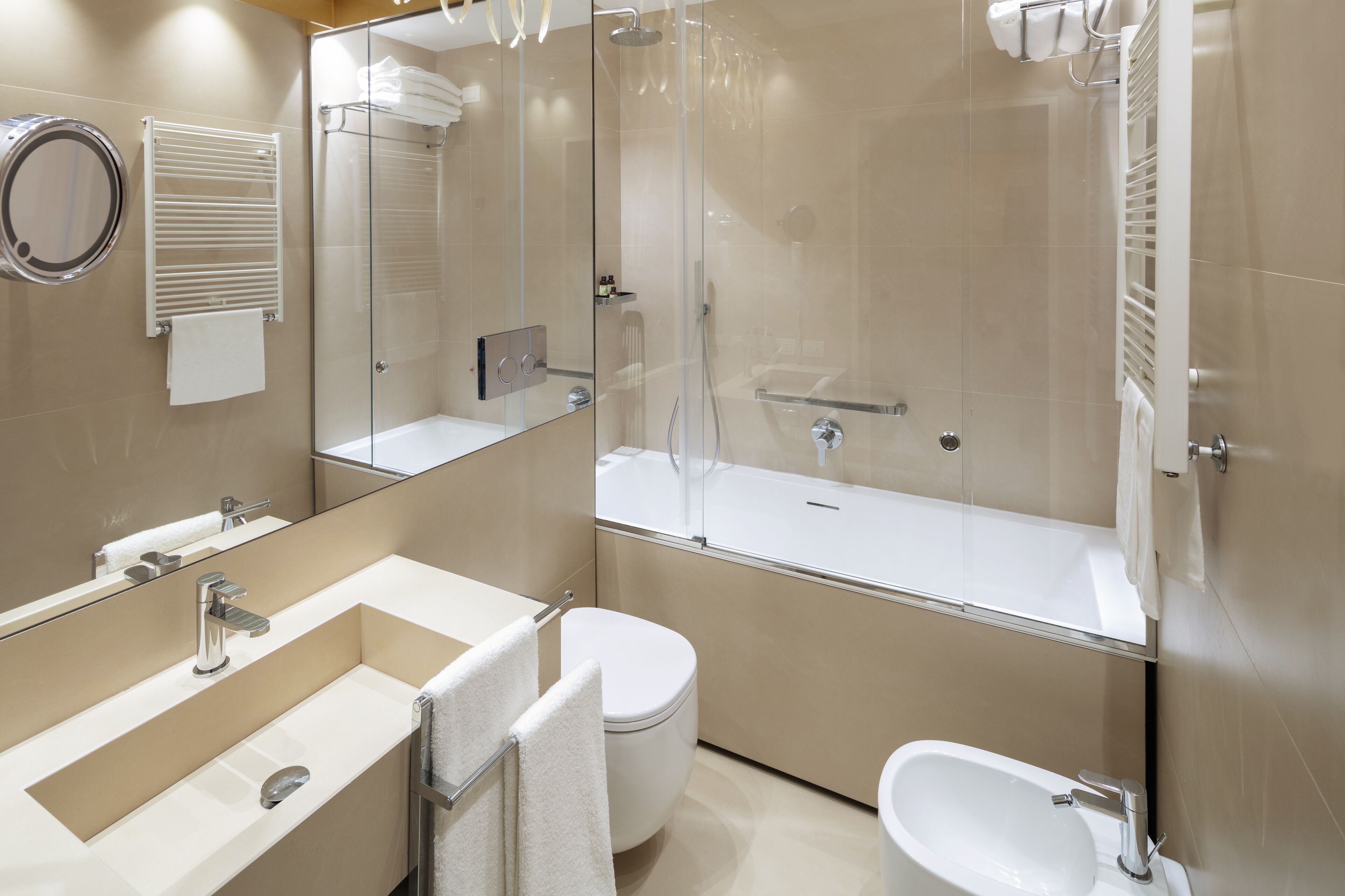 A modern bathroom with a glass-enclosed shower, a bathtub, a toilet, and a sink with a mirror.